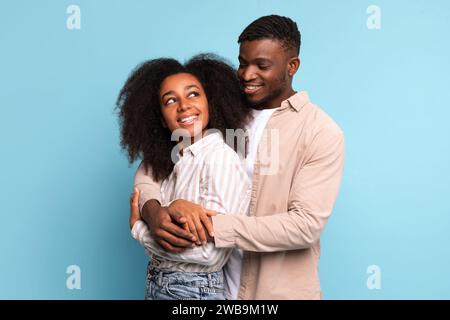 afroamerikanisches Paar, das auf blauem Hintergrund lächelt Stockfoto