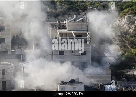 Jerusalem, Israel. Januar 2024. Der Rauch steigt, als israelische Sicherheitskräfte das Haus zweier Hamas-Militanten im palästinensischen Ostjerusalem-Viertel Sur Bahir zerstören. Auf Anweisung des israelischen Premierministers Benjamin Netanjahu wurden zwei Häuser von zwei palästinensischen Brüdern zerstört, die angeblich den Tod von drei Israelis bei einem bewaffneten Angriff am 30. November verursacht haben sollen. Israelische Truppen umzingelten die Häuser der Brüder Murad und Ibrahim Nemr in der Stadt Sur Bahir und sprengten sie mit einer Bombe. Quelle: SOPA Images Limited/Alamy Live News Stockfoto