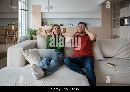 Gestresstes, unglückliches Paar, das unter lauten Nachbarn leidet. Nachteile des Wohnens im Wohnhaus Stockfoto