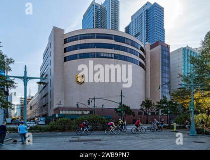 Die markante, geschwungene, beige Ziegelfassade des UPS Service Centers überblickt die 12th Avenue und den Hudson River Greenway in Manhattans Hell’s Kitchen. Stockfoto