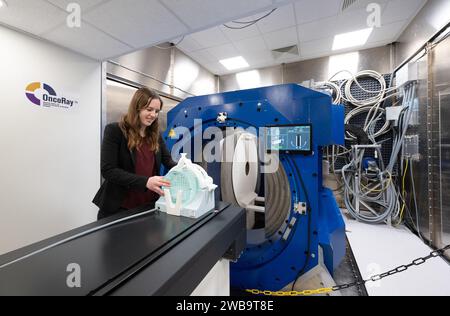 09. Januar 2024, Sachsen, Dresden: Franciska Lebbink, wissenschaftliche Mitarbeiterin, positioniert eine mit Wasser gefüllte Dummy an der Protonentherapieeinrichtung vor der offiziellen Inbetriebnahme eines wissenschaftlichen Prototyps für kontrastreiche Live-Bildgebung in der Protonentherapie am OncoRay, dem Nationalen Zentrum für Strahlenforschung in der Onkologie des Universitätsklinikums Dresden. Mit der weltweit einzigartigen Kombination von Magnetresonanztomographie (MRT) und Protonentherapie (PT) in Form eines Prototyps soll es künftig möglich sein, Patienten während ihrer Strahlenbehandlung mittels Echtzeit-MRT-Bildgebung zu überwachen und damit zu signieren Stockfoto