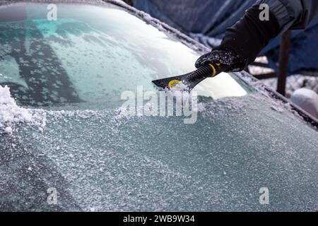 Krakau, Polen, 9. Januar 2024. Ein Mann entfernt Schnee und Eis aus seinem Auto, während die Temperaturen deutlich unter Null fielen und Schnee den größten Teil der Stadt bedeckt. Quelle: Dominika Zarzycka/Alamy Live News. Stockfoto