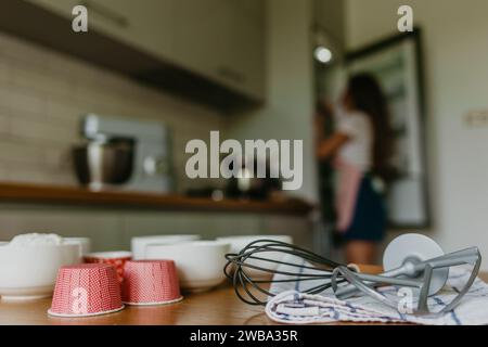 Verschiedene Cupcake-Liner in verschiedenen Farben mit Muffinpfanne und Drahtquirl. Stockfoto
