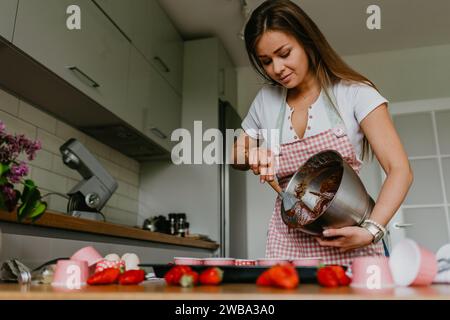 Eine junge Frau, die einen frisch gebackenen Cupcake hält. Stockfoto