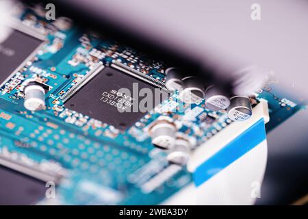 Tokio, Japan – 29. März 2023: Detaillierte Makroaufnahme einer elektronischen Leiterplatte, die den Mikrochip und die umliegenden Kondensatoren hervorhebt. Stockfoto