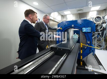 09. Januar 2024, Sachsen, Dresden: Michael Kretschmer (CDU, l), Ministerpräsident von Sachsen, und Aswin Hoffmann vom Institut für Radioonkologie - OncoRay am Helmholtz-Zentrum Dresden-Rossendorf (HZDR) stehen bei der offiziellen Inbetriebnahme eines wissenschaftlichen Prototyps für kontrastreiche Live-Bildgebung in der Protonentherapie bei OncoRay. das nationale Zentrum für Strahlenforschung in der Onkologie am Universitätsklinikum Dresden. Mit der weltweit einzigartigen Kombination aus Magnetresonanztomographie (MRT) und Protonentherapie (PT) in Form eines Prototyps sollte es po sein Stockfoto