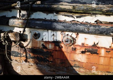 Nahaufnahme der Seite eines alten hölzernen Schiffes, das Rostflecken und verfaulte Hölzer abblättert Stockfoto
