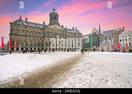 Verschneite Dam in Amsterdam Niederlande im Winter bei Sonnenuntergang Stockfoto