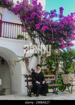 Porträt eines Mönchs mit einem großen Lächeln im Gesicht im Innenhof des Klosters Panagia Tourliani in Ano Mera, Mykonos, Kykladen, Griechenland Stockfoto