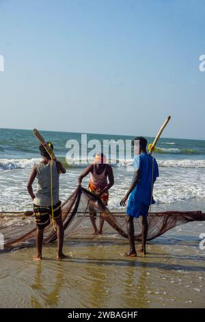 Fischer am Strand von Benaulim im indischen Goa ziehen ihre Netze an Land und sortieren den Fang Stockfoto