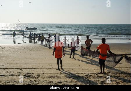 Fischer am Strand von Benaulim im indischen Goa ziehen ihre Netze an Land und sortieren den Fang Stockfoto