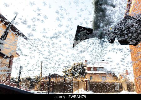 Ein Mann entfernt Schnee und Eis aus seinem Auto, während die Temperaturen unter Null fielen und Schnee den größten Teil der Stadt bedeckt. Stockfoto