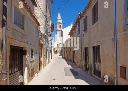 Bild einer typischen Straßenszene aus der historischen kroatischen Stadt Voznjan mit Kopfsteinpflasterstraßen und alten Gebäuden im Morgenlicht Stockfoto