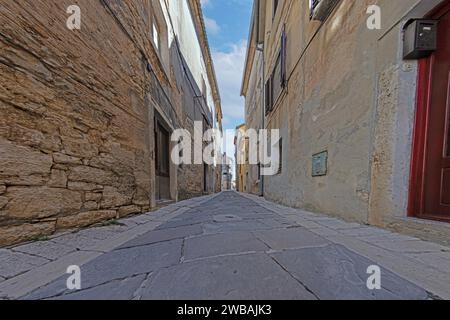 Bild einer typischen Straßenszene aus der historischen kroatischen Stadt Voznjan mit Kopfsteinpflasterstraßen und alten Gebäuden im Morgenlicht Stockfoto