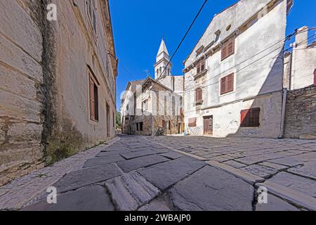 Bild einer typischen Straßenszene aus der historischen kroatischen Stadt Voznjan mit Kopfsteinpflasterstraßen und alten Gebäuden im Morgenlicht Stockfoto