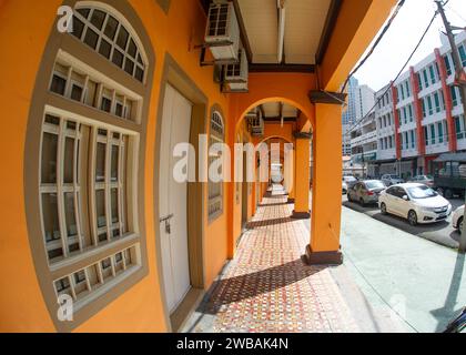 Penang, Malaysia - 20. Bis 2023. Februar - Straßen mit orangefarbenen Bögen entlang der sonnigen Straße, an der Autos vorbeifahren. Stockfoto