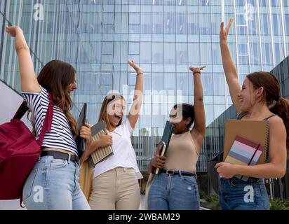 Eine Gruppe von Schülerinnen im Teenageralter, die Erfolge auf dem Campus feiern. Glückliche Millennials-Studenten Stockfoto