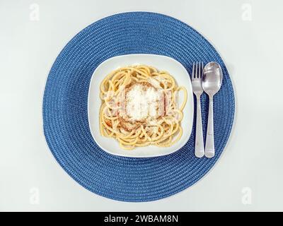 Spaghetti, serviert in einer weißen Schüssel auf einem Tisch, direkt von oben geschossen Stockfoto