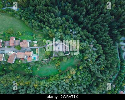 Ein altes Schloss am Ende eines Dorfes, fotografiert mit einer Drohne Stockfoto