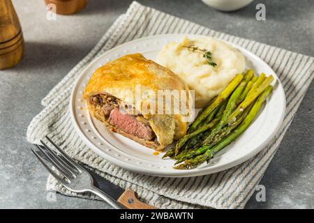 Hausgemachte, individuelle Rindfleisch-Wellingtons mit Spargel und Kartoffeln Stockfoto