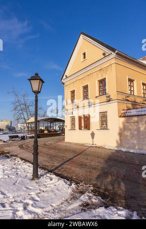 Minsk, Weißrussland - 7. Januar 2024: Dreifaltigkeitsvorort, vertikaler Straßenblick mit alten Wohnhäusern an einem sonnigen Wintertag Stockfoto