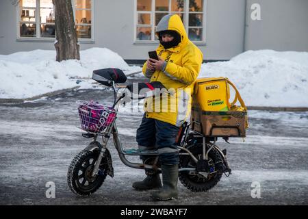 Moskau, Russland. Januar 2024. Ein Kurier des Yandex-Lieferservice erhält eine Bestellung im VDNKh-Messezentrum in Moskau bei sehr kaltem Wetter in Russland. Stockfoto