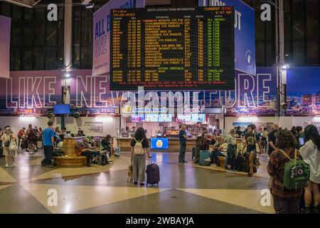 Boston, MA, USA-8. September 2023: Passagiere lesen Schild am Bahnhof South Station, einem belebten Bahnhof. Stockfoto