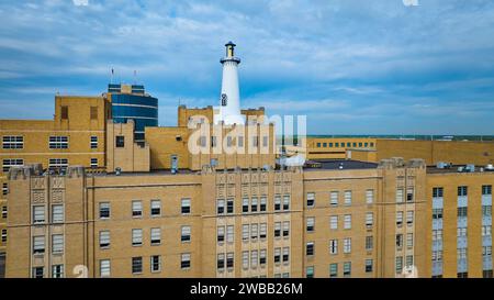 Blick aus der Vogelperspektive auf den urbanen Leuchtturm und das Vintage-Gebäude vor dem Stadtbild Stockfoto