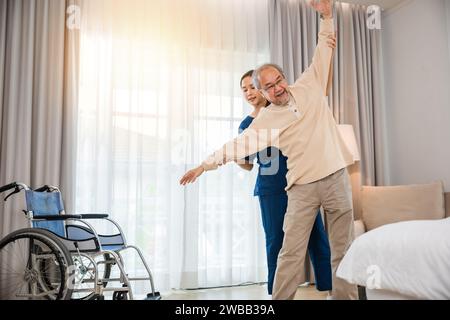 Der alte Senior-Mann trainiert zu Hause gern mit einem Physiotherapeuten für ausgestreckte Arme Stockfoto