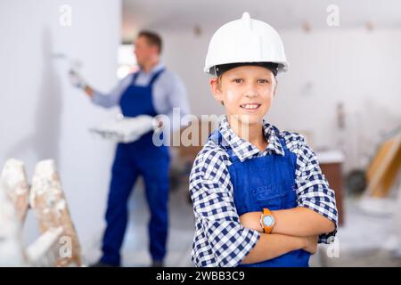 Porträt eines lächelnden Jungen, der insgesamt blau trägt Stockfoto