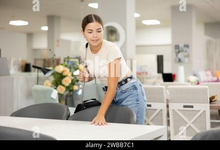 Die Käuferin im Möbelhaus wählt einen neuen, modernen Tisch für ihr Zuhause Stockfoto