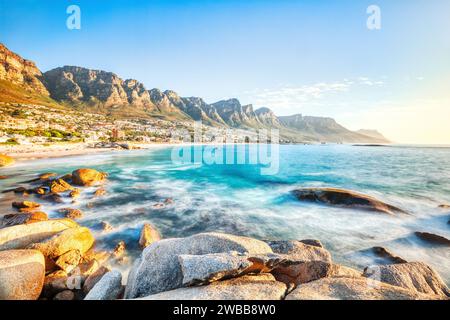Sonnenuntergang in Kapstadt über Camps Bay Beach mit Tafelberg und zwölf Aposteln im Hintergrund, Südafrika Stockfoto
