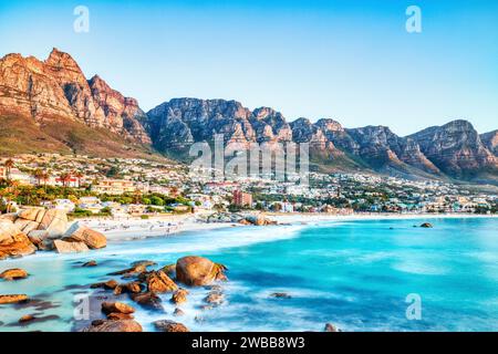 Sonnenuntergang in Kapstadt über Camps Bay Beach mit Tafelberg und zwölf Aposteln im Hintergrund, Südafrika Stockfoto