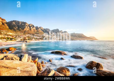 Sonnenuntergang in Kapstadt über Camps Bay Beach mit Tafelberg und zwölf Aposteln im Hintergrund, Südafrika Stockfoto