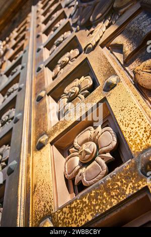 Verzierte Bronze-Blumenschnitzereien an der Architekturtür - niedriger Winkel Stockfoto