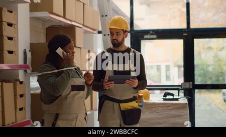 Lagerbetrieb Manager und Mitarbeiter bereiten Bestellungen für die Lieferung vor, erhalten Telefonanruf vom Management mit neuen Anweisungen im Lager, während Etiketten auf den zu versendenden Paketen gescannt werden Stockfoto