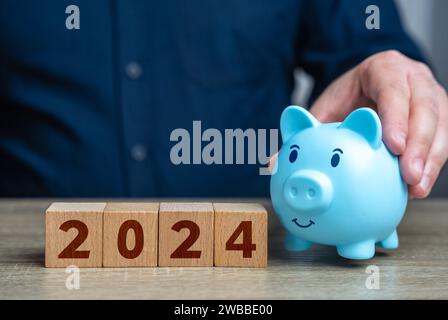 Finanzverwaltung im Jahr 2024. Budget- und Aufwandsplanung. Wirtschaft und Finanzen. Geschäftsmann, der eine Sparkasse hält. Stockfoto