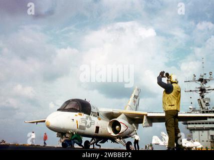 Ein Flugzeugdirektor gibt dem Piloten eines S-3A Viking Anweisungen, während das Flugzeug während des Flugbetriebs auf einem Katapult auf dem nuklearbetriebenen Flugzeugträger USS THEODORE ROOSEVELT (CVN-71) 1987 positioniert wird Stockfoto