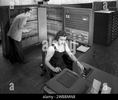 Mann und Frau, die mit der elektronischen Datenverarbeitungsmaschine IBM Typ T04 arbeiten, NASA Langley Research Center, Hampton, Virginia, USA, National Advisory Committee for Aeronautics, 1957 Stockfoto