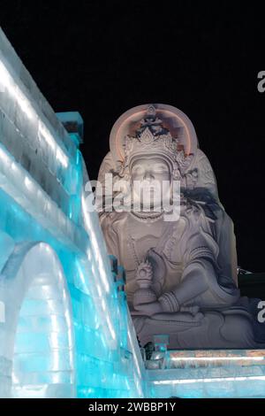 HARBIN, CHINA - 1. Januar 2022: Vertikale Abbildung der spektakulären beleuchteten weißen Eisskulpturen beim Harbin Ice and Snow Festival in Harbin, Hei Stockfoto