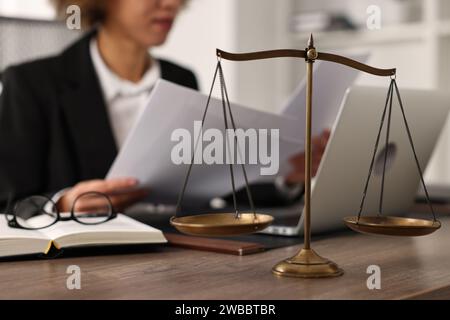 Notar arbeitet mit Dokumenten am Arbeitsplatz im Büro, Schwerpunkt auf der Skala der Gerechtigkeit Stockfoto