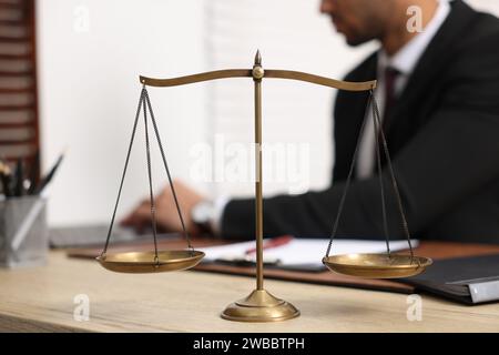 Anwalt arbeitet am Tisch im Büro, konzentriert sich auf die Maßstäbe der Gerechtigkeit Stockfoto