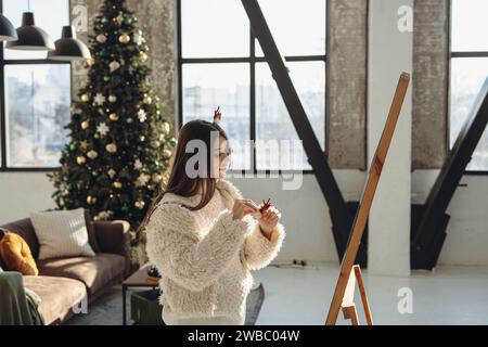 Eine lebendige junge Dame, die eine weihnachtliche Rentiermaske trägt, strahlt Glück aus. Stockfoto