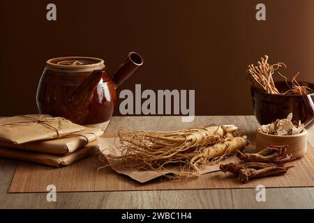 Porzellantopf mit Ginseng und seltenen Kräutern auf Holztisch und braunem Hintergrund. Arzneimittel aus dem alten China, Gesundheitsschutz Stockfoto