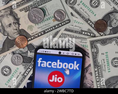 Deutschland. Januar 2024. In dieser Fotoabbildung ist ein Reliance Jio Infocomm Limited Logo auf einem Smartphone mit US-Dollar-Banknoten und -Münzen im Hintergrund zu sehen. Quelle: SOPA Images Limited/Alamy Live News Stockfoto