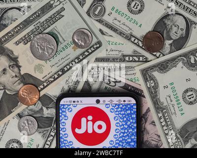 Deutschland. Januar 2024. In dieser Fotoabbildung ist ein Reliance Jio Infocomm Limited Logo auf einem Smartphone mit US-Dollar-Banknoten und -Münzen im Hintergrund zu sehen. Quelle: SOPA Images Limited/Alamy Live News Stockfoto