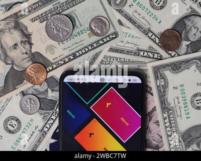 Deutschland. Januar 2024. In dieser Fotoabbildung ist ein RedKix-Logo auf einem Smartphone mit US-Dollar-Banknoten und -Münzen im Hintergrund zu sehen. Quelle: SOPA Images Limited/Alamy Live News Stockfoto