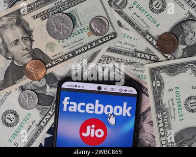Deutschland. Januar 2024. In dieser Fotoabbildung ist ein Reliance Jio Infocomm Limited Logo auf einem Smartphone mit US-Dollar-Banknoten und -Münzen im Hintergrund zu sehen. (Foto von Igor Golovniov/SOPA Images/SIPA USA) *** ausschließlich für redaktionelle Nachrichten *** Credit: SIPA USA/Alamy Live News Stockfoto