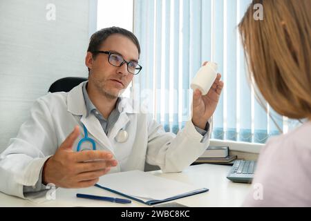 Schmerzlinderung Heilmittel, Multivitaminverschreibung, Gesundheits- und Werbekonzept. Männlicher Arzt im weißen Mantel, der Medikamente zeigt, medici verschreibt Stockfoto