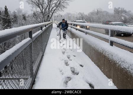 Chicago, USA. 9. Januar 2024. Chicago Wetter : Ein Radfahrer spaziert mit seinem Fahrrad, während in den westlichen Vororten Chicagos starker Schnee fällt. Am Ende der Woche wird noch mehr Schnee erwartet, bevor die Temperaturen von -14 °C und darunter deutlich kälter werden. Quelle: Stephen Chung / Alamy Live News Stockfoto